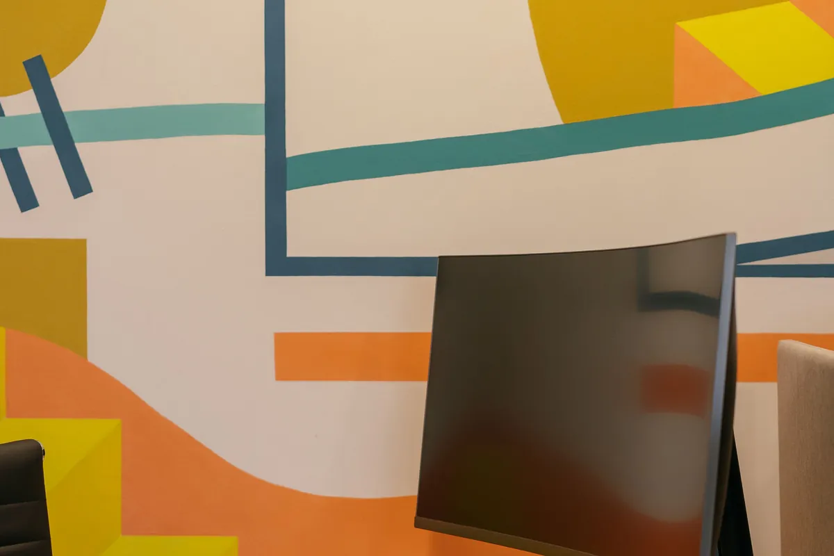 Workstation with a laptop against a bright painted wall