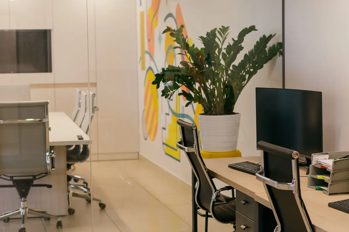 Office corner with desks and a colorful mural on the wall